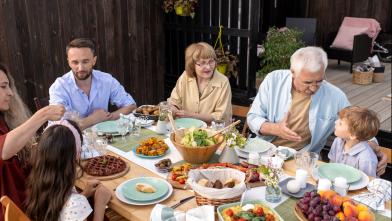 Multi-generational family eating healthy meal at picnic table