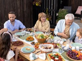 Multi-generational family eating healthy meal at picnic table