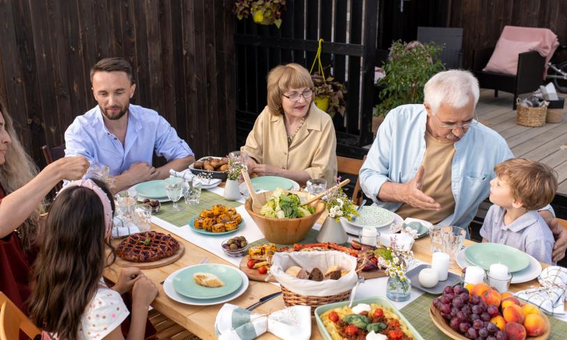 Multi-generational family eating healthy meal at picnic table