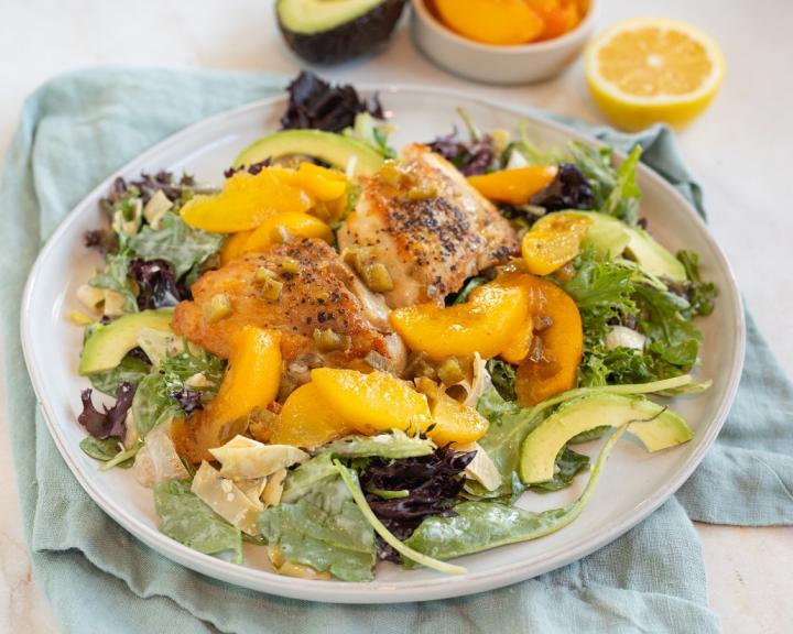 A plate with chicken, peaches, and homemade diabetes friendly dressing for a low carb style meal