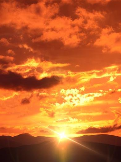 Fiery sunset over dark landscape