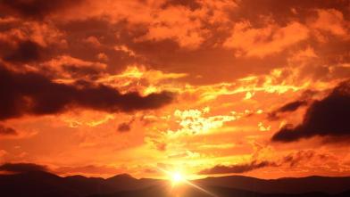 Fiery sunset over dark landscape