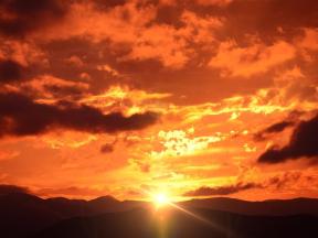 Fiery sunset over dark landscape