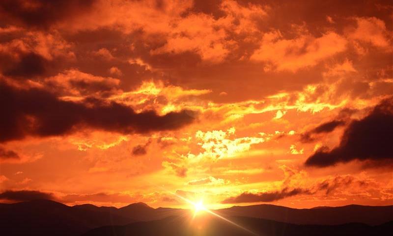 Fiery sunset over dark landscape
