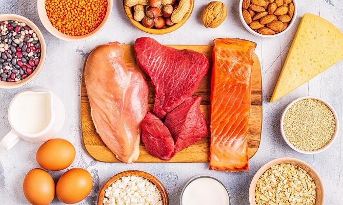 An assortment of protien rich foods like chicken, steak, salmon, almonds, eggs, and nuts. 