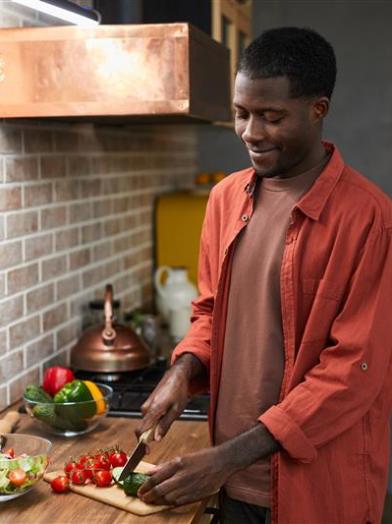 A man preparing a solo meal for himself that is healthy and diabetic friendly with veggies