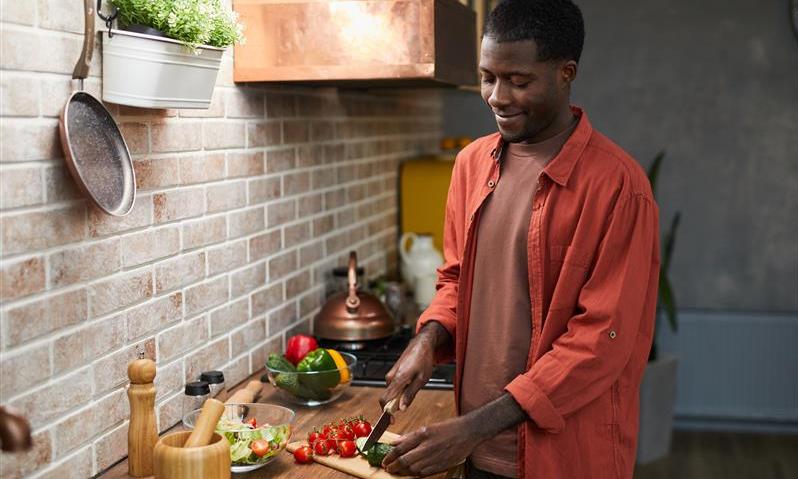 A man preparing a solo meal for himself that is healthy and diabetic friendly with veggies