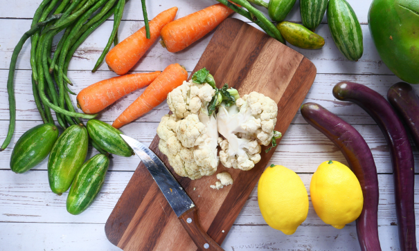 A chopping board with cauliflower surrounded by veggies perfect for a healthy diabetic diet