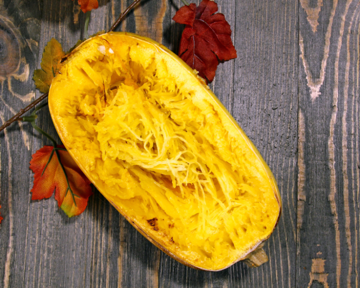 A sliced spaghetti squash on wood background representing a low carb alternative to spaghetti for diabetes friendly meal